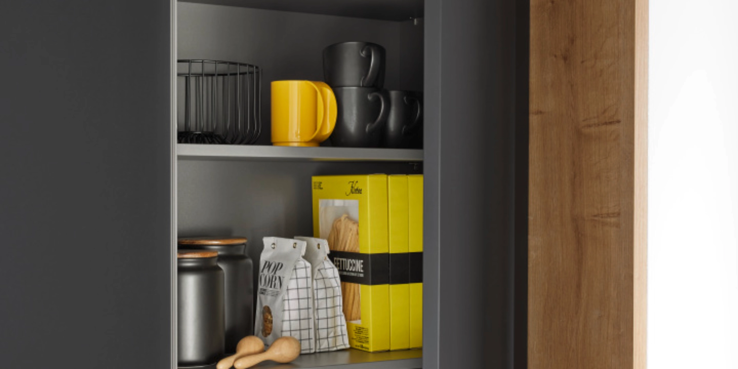 Un placard de cuisine ouvert avec vaisselle et aliments, conçu par Nolte Kitchen.