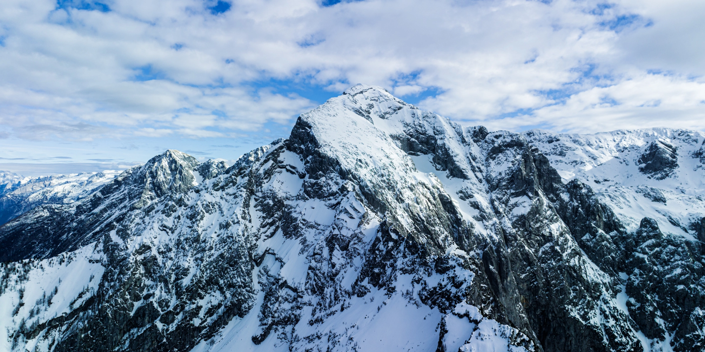 Snowy mountain landscape under a blue sky.