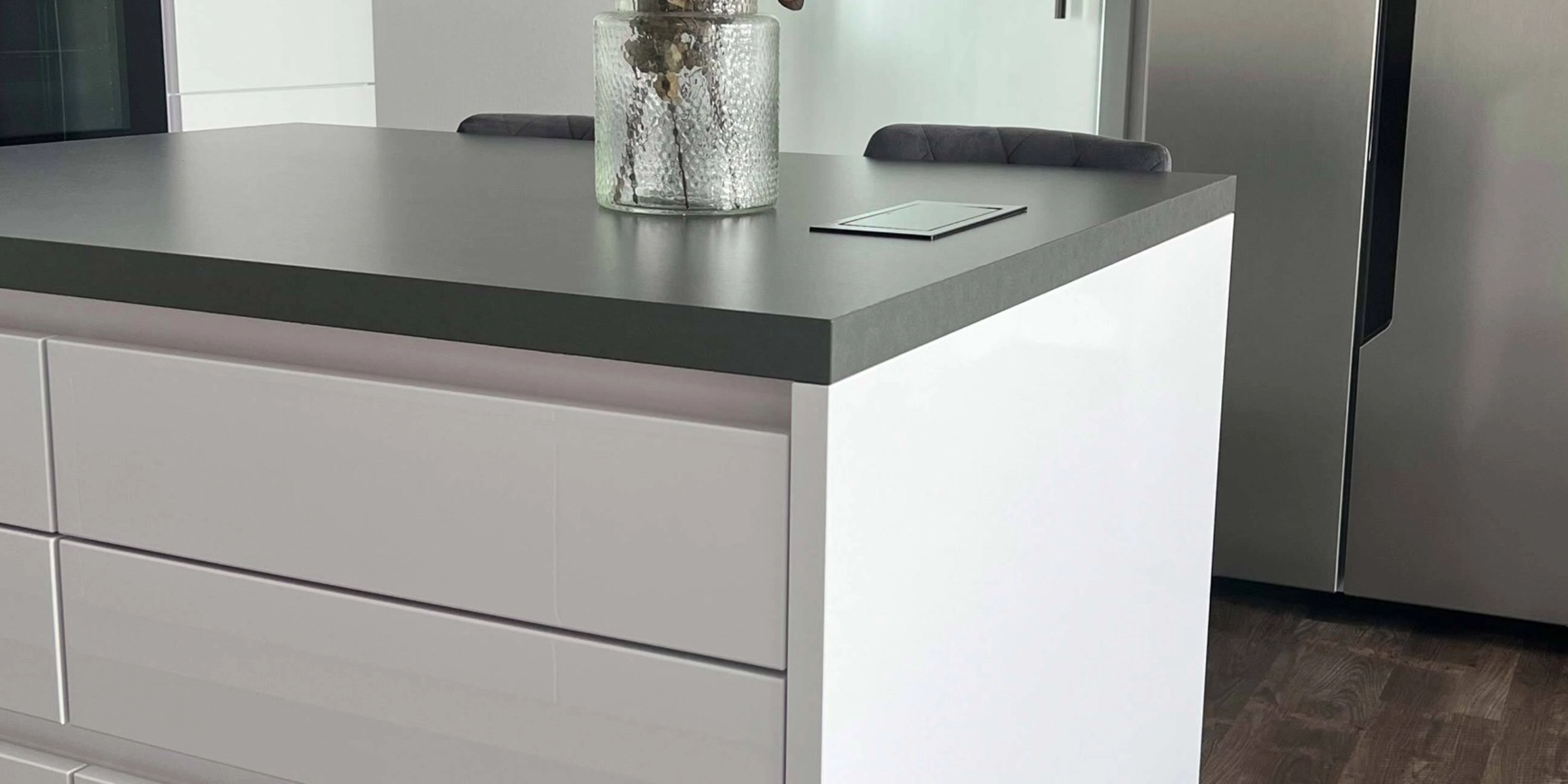 Une cuisine moderne avec un îlot blanc et des appareils en acier inoxydable, Nolte Kitchen.