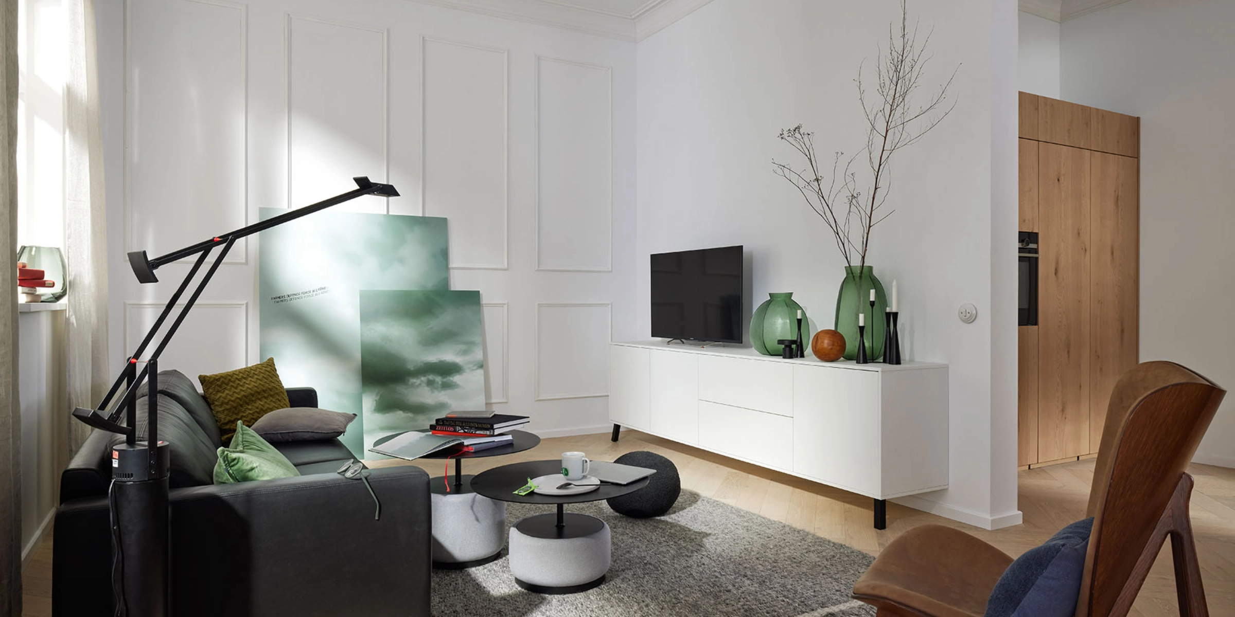 Un salon élégant avec des meubles modernes et une télé sur un buffet. Nolte Living.