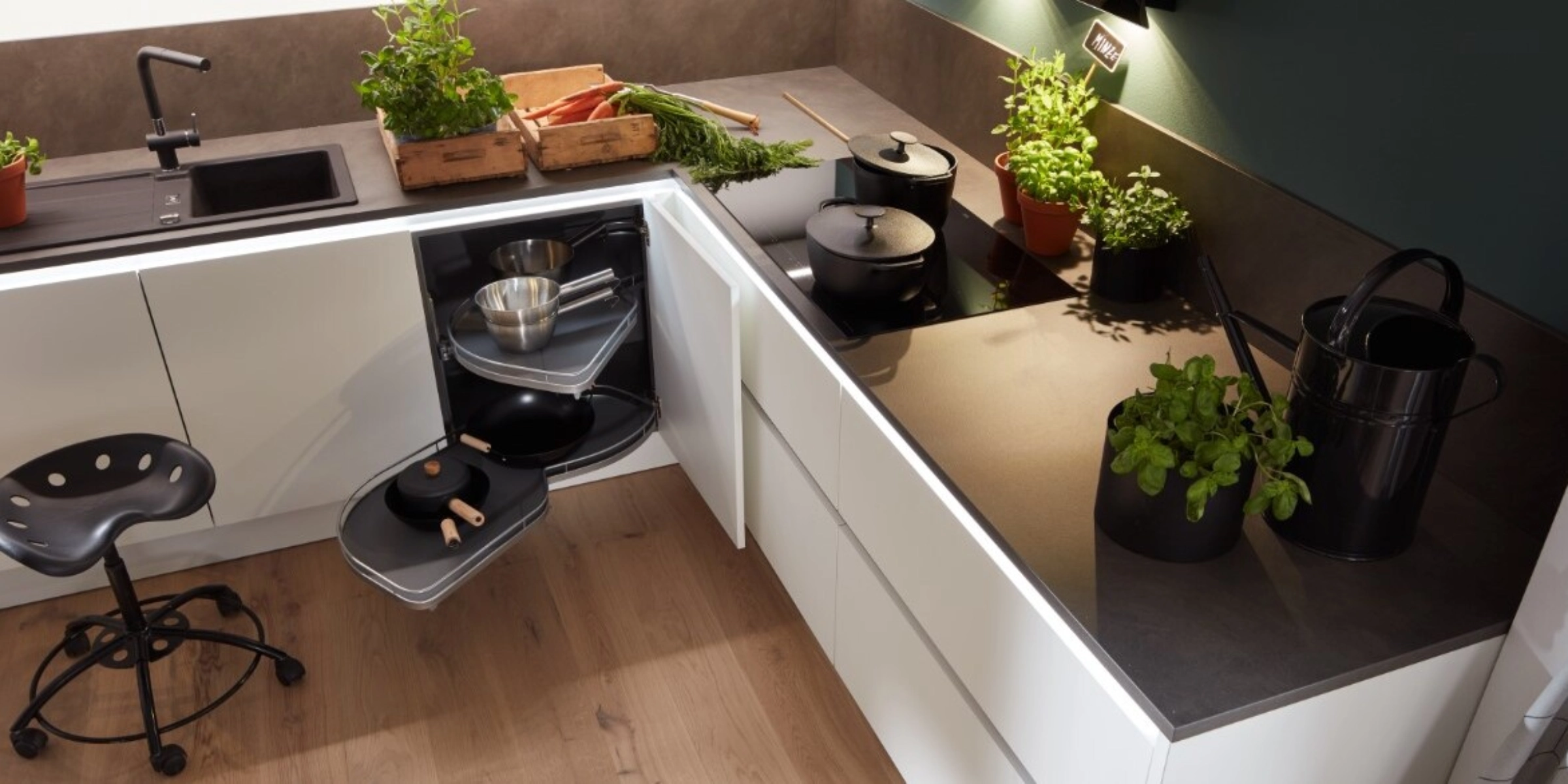 Cuisine Nolte à la conception ergonomique avec le programme de façades PLUS en blanc softmatt, hauteur de travail optimale et organisation réfléchie de l'espace de rangement – herbes fraîches et tiroirs ouverts montrent des détails de cuisine malins.