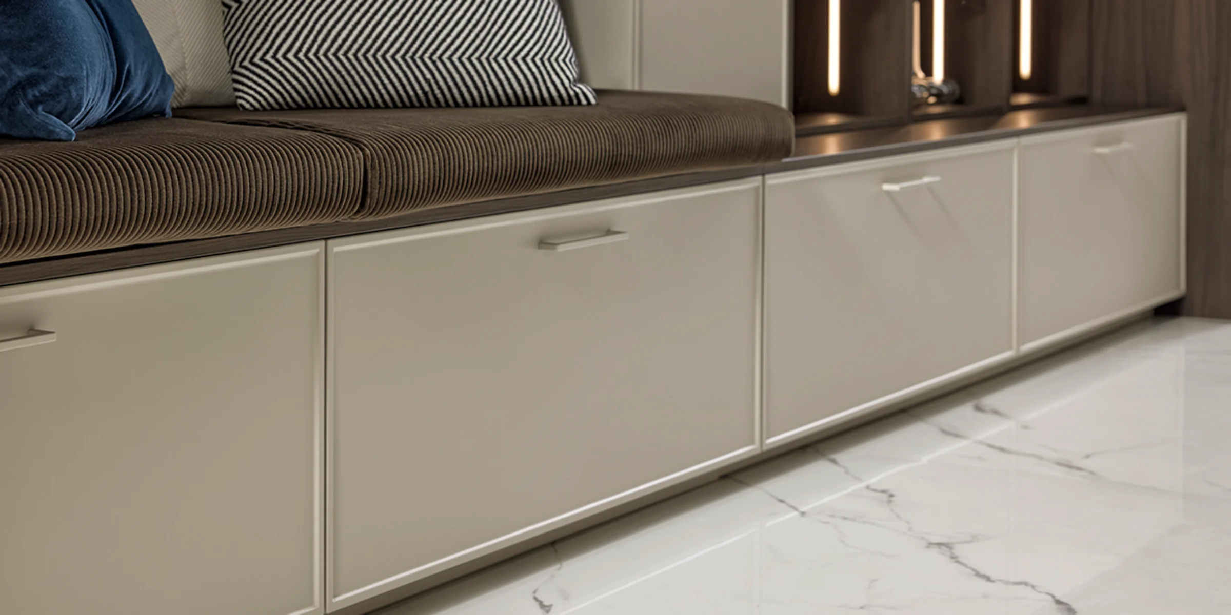 Area salotto con eleganti armadi e cuscini di stile, Nolte Living.