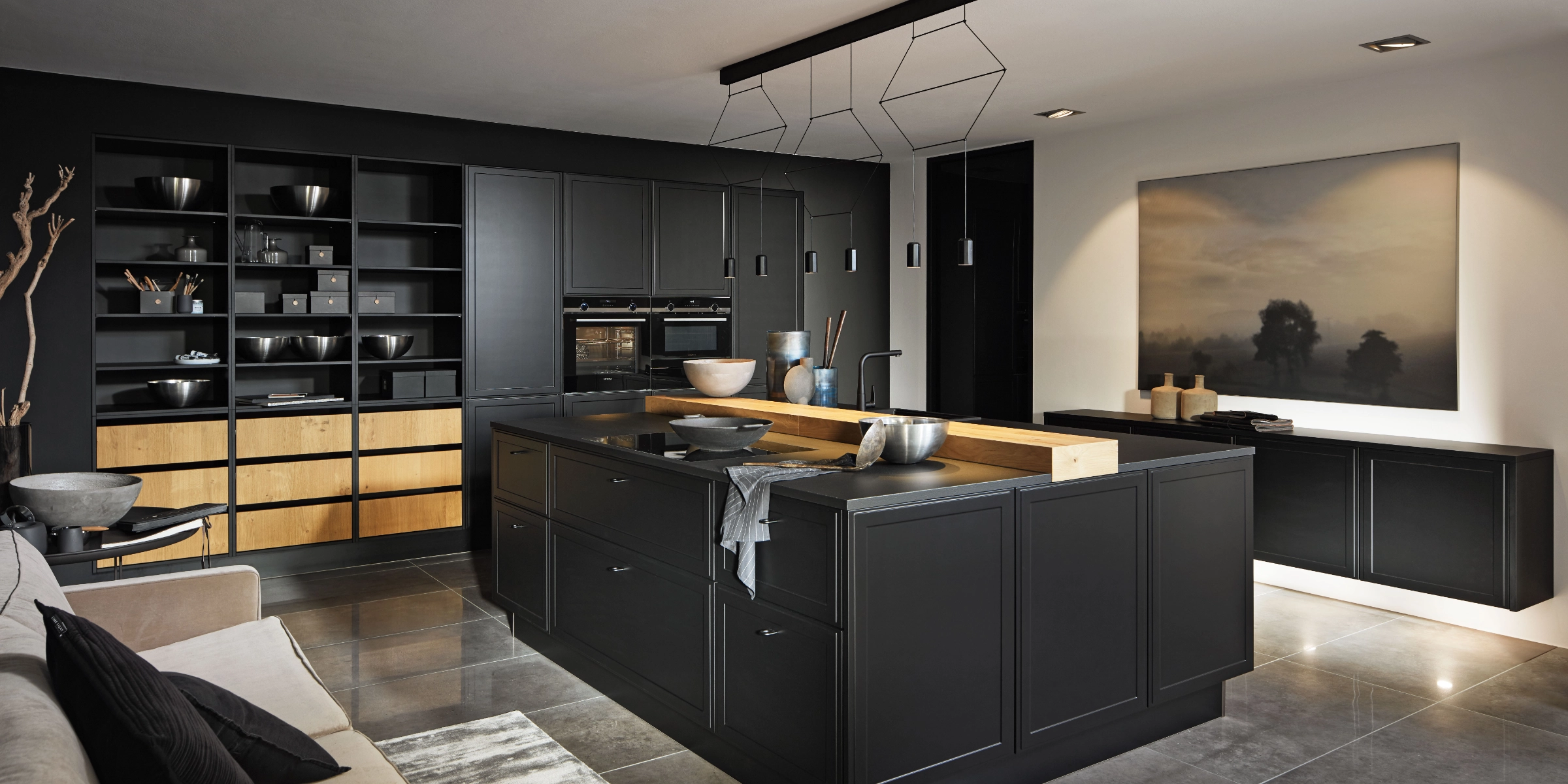 Une cuisine moderne aux tons sombres avec îlot et élégants placards de Nolte Kitchen.