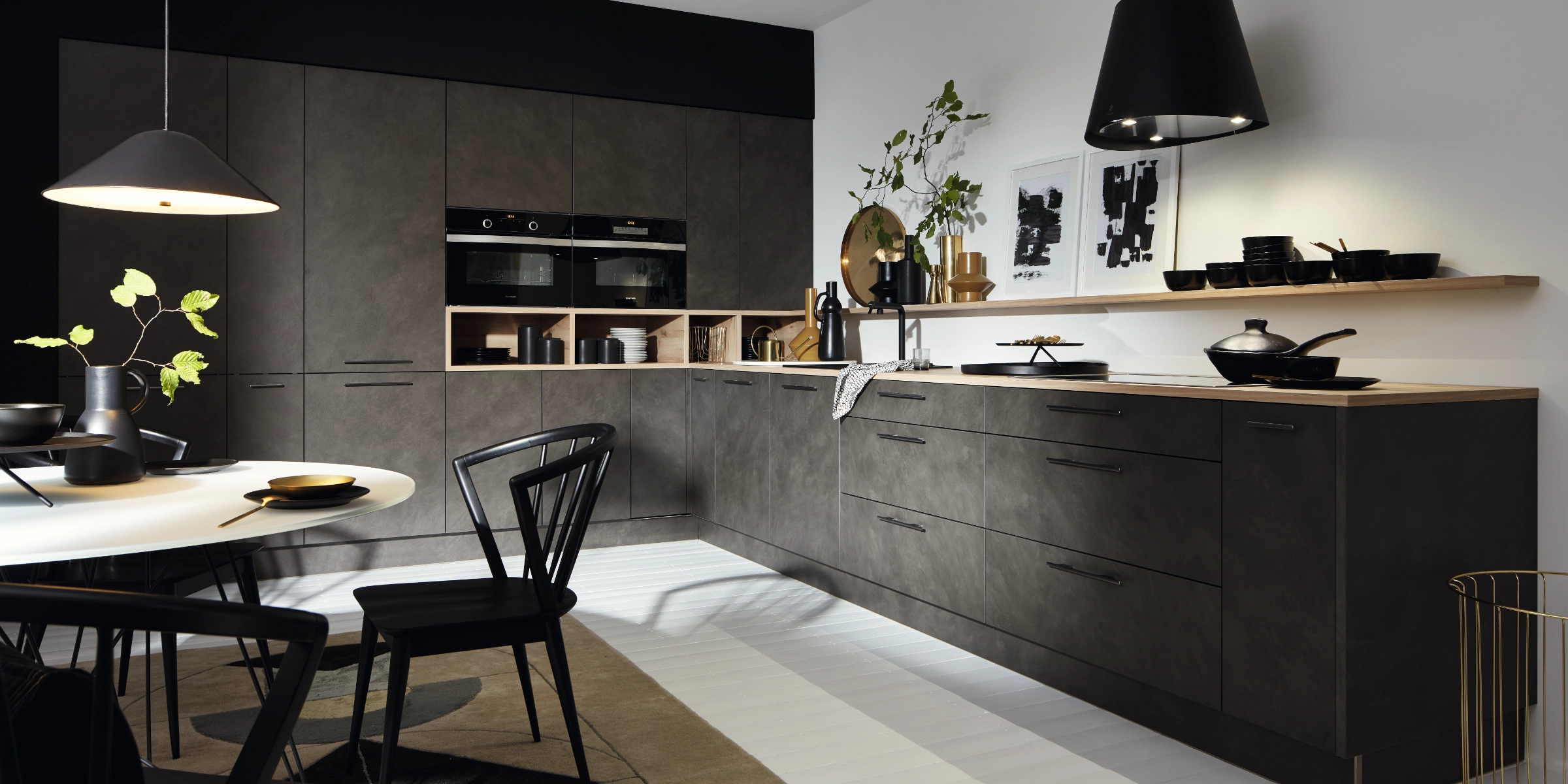 Cuisine moderne avec armoires sombres, table à manger et décorations, conçue par Nolte Kitchen.