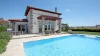 Ein modernes Haus mit Pool im Garten unter blauem Himmel.