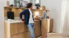 A man and a woman chatting in a modern kitchen with wooden cabinets by Nolte Kitchen.