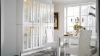 A stylish dining area with white furniture and glass doors exudes elegance, complemented by Nolte Living.