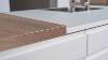 Una barra de cocina moderna con superficies de madera y blancas de Nolte Cocina.