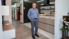 Un homme se tient dans une cuisine moderne de Nolte Kitchen.