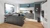 Modern kitchen with an island and gray cabinets in a bright room, Nolte Kitchen.
