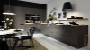 Cuisine moderne avec armoires sombres et éclairage élégant, conçue par Nolte Kitchen.