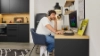 A man works at a desk with a computer in a modern Nolte Kitchen kitchen.