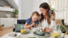 Une mère et sa fille prennent le petit-déjeuner ensemble dans une cuisine moderne de Nolte Kitchen.