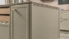 Cuisine moderne avec îlot et armoires beiges, conçue par Nolte Kitchen.