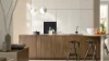 Una cocina moderna con frentes de madera y lámparas colgantes. Nolte Küchen.