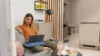 Una mujer sentada en un sofá con una laptop en una sala moderna. Nolte Living.