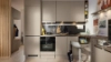 A modern Nolte kitchen features beige cabinets and a black backsplash.