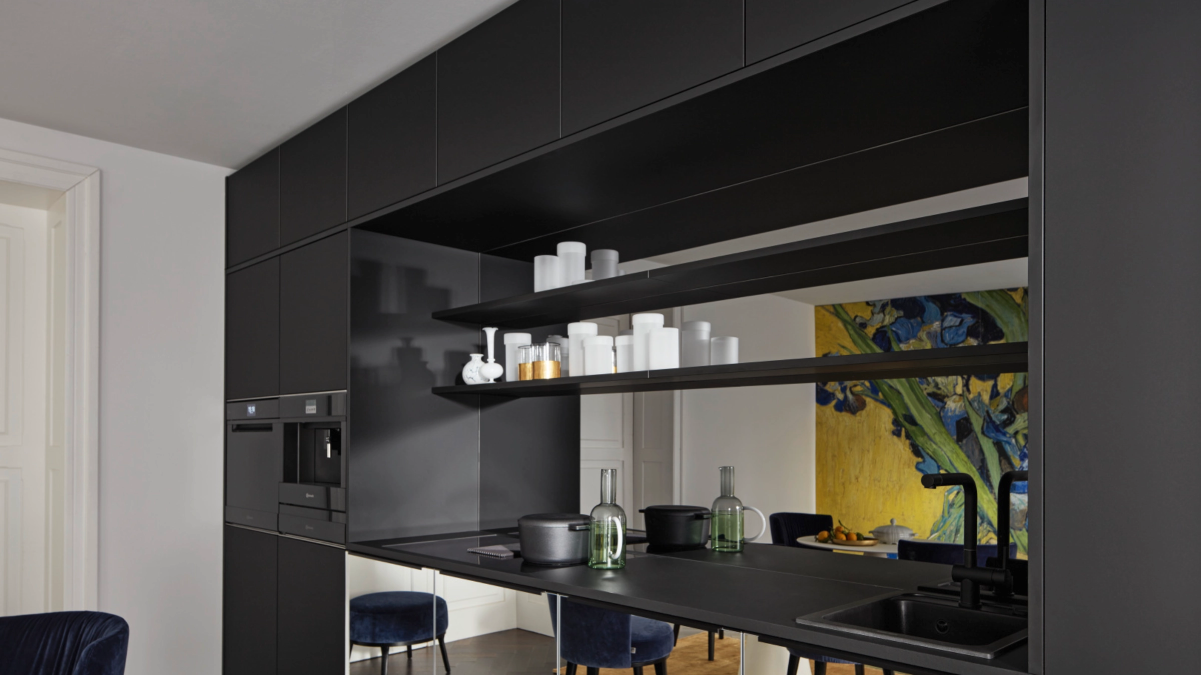 Une cuisine moderne noire avec étagères et appareils, conçue par Nolte Kitchen.