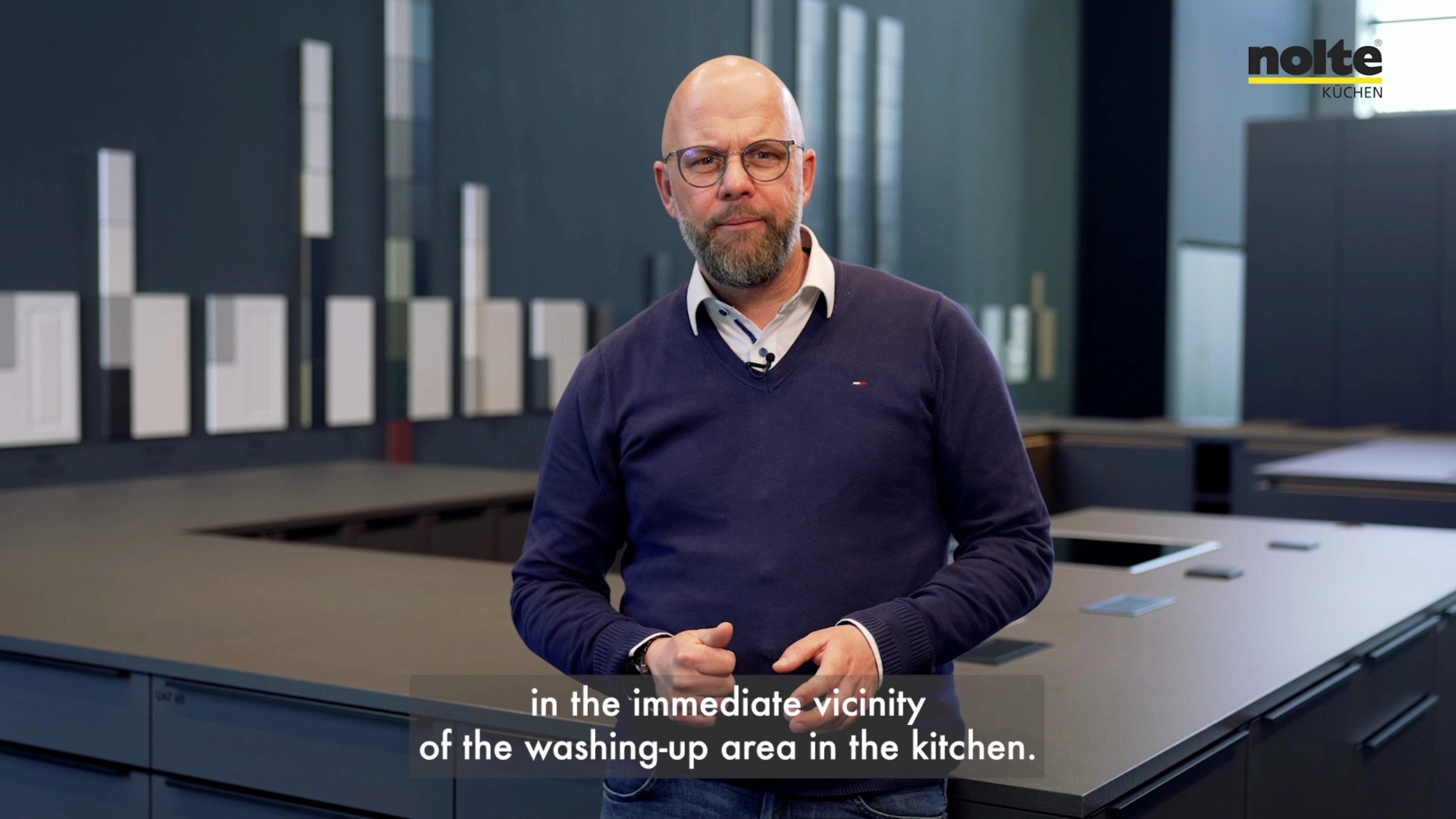 Une cuisine moderne avec un homme au premier plan, Nolte Kitchen.