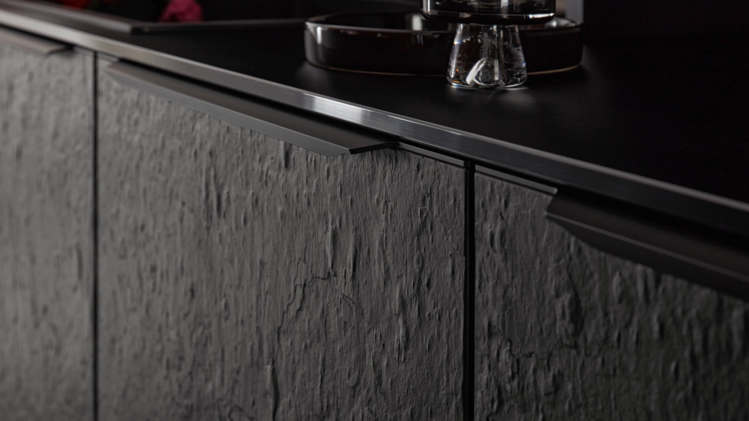 Une cuisine moderne avec façades sombres texturées et détails élégants de Nolte Kitchen.