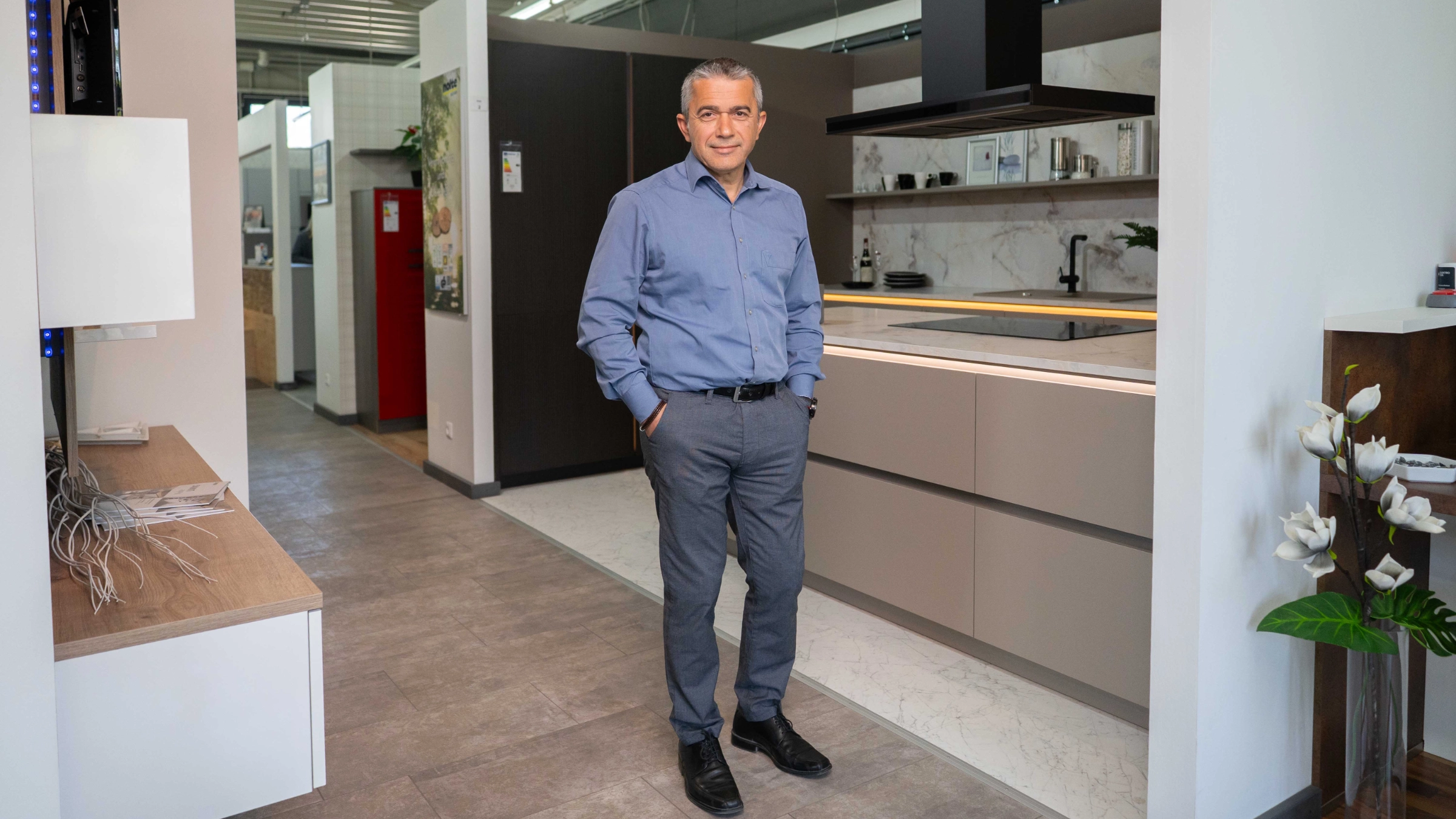 Un homme se tient dans une cuisine moderne de Nolte Kitchen.