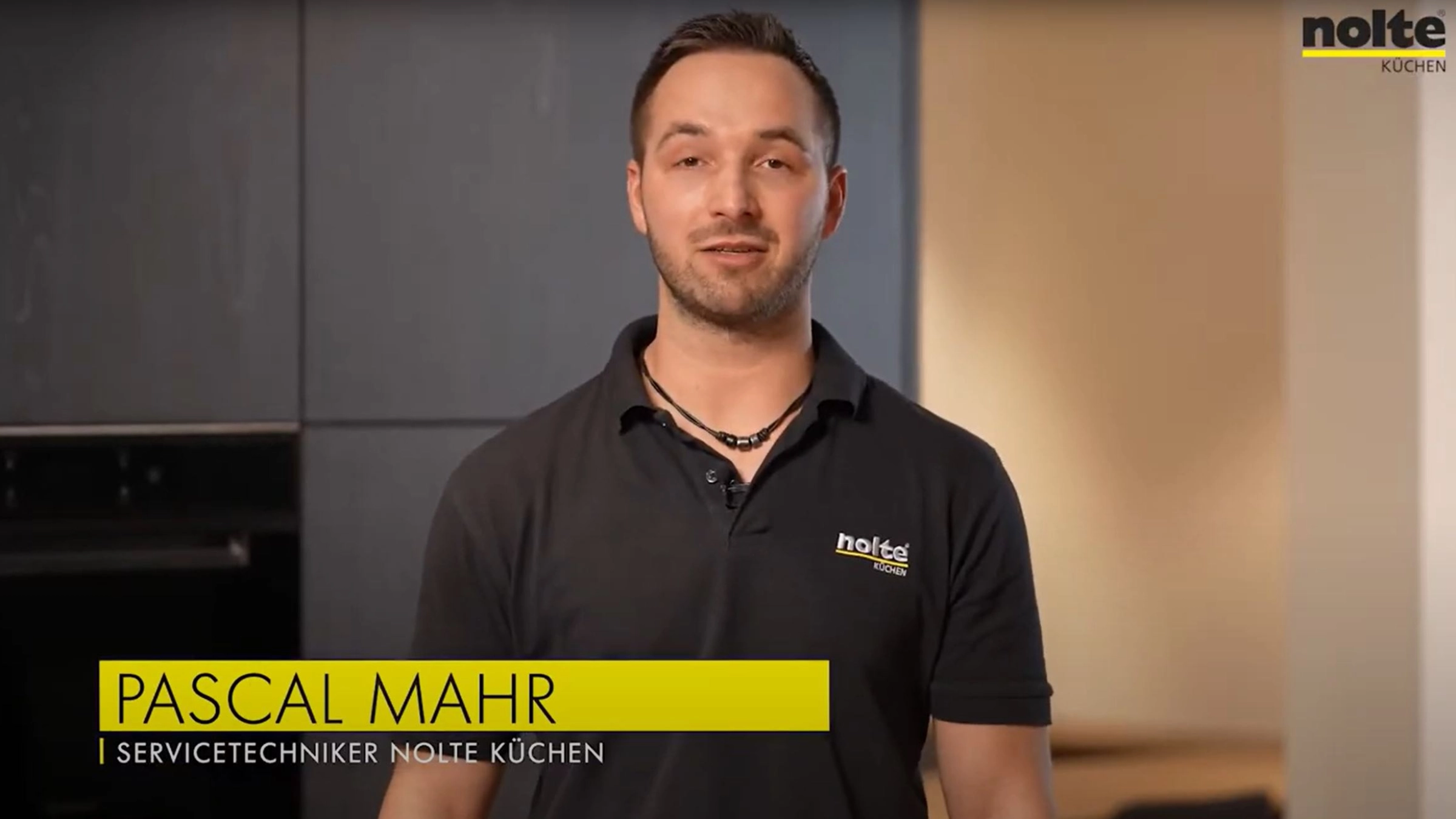 Ein Servicetechniker steht in einer modernen Küche von Nolte Küchen.