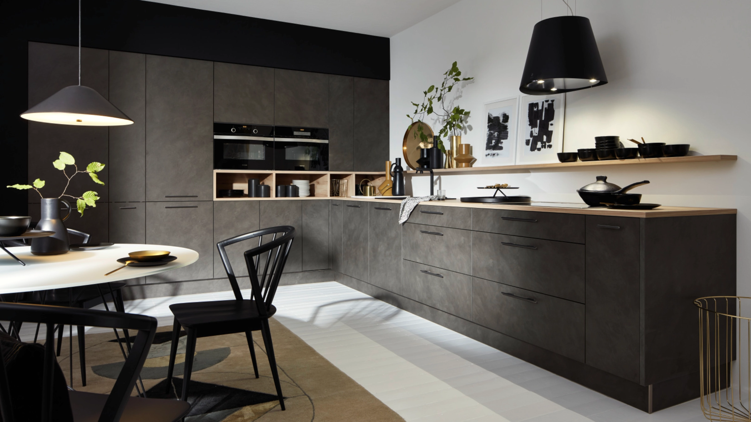 Cuisine moderne avec armoires sombres et éclairage élégant, conçue par Nolte Kitchen.