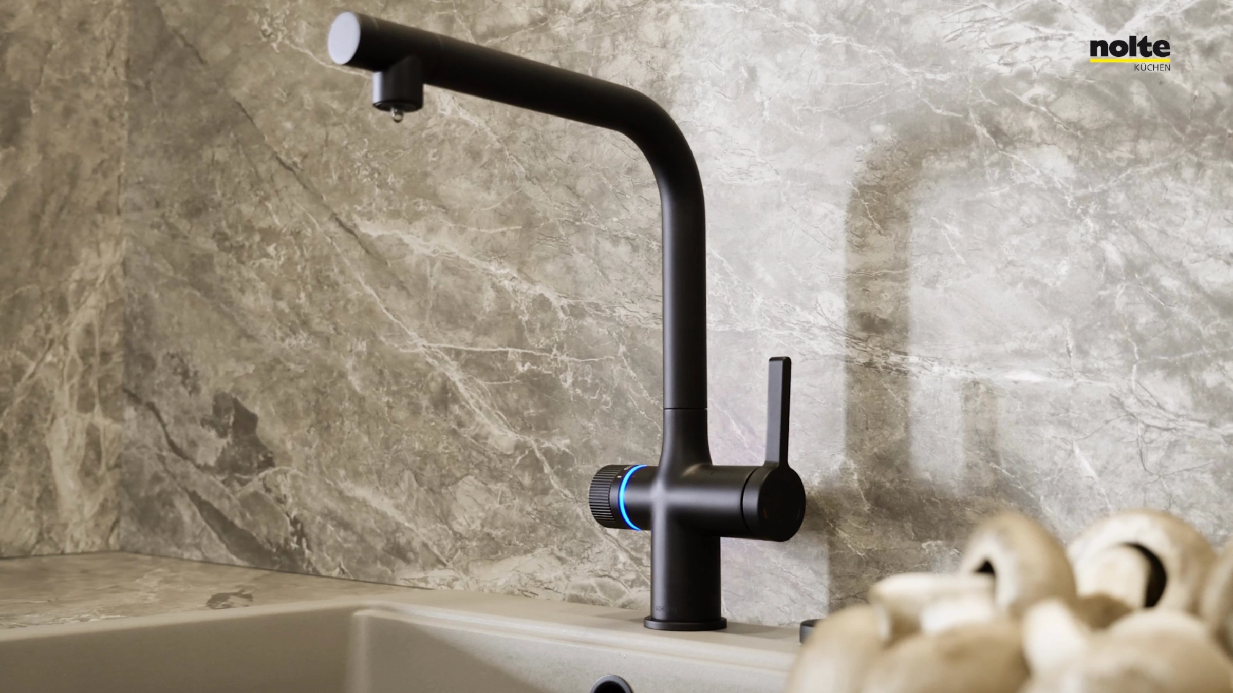 Ein stilvoller Wasserhahn in einer modernen Küche aus Marmoroptik, Nolte Küchen.