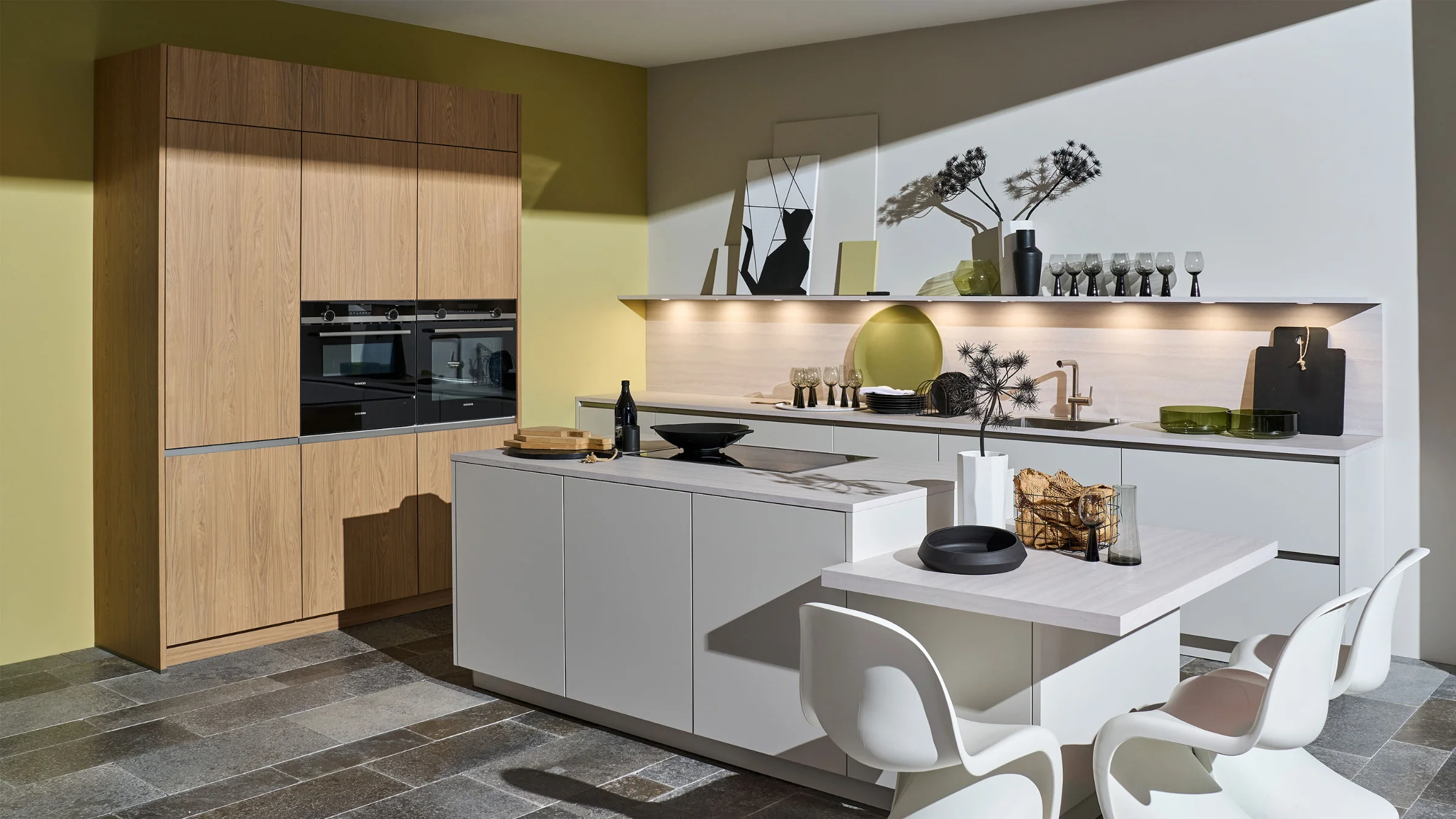 Moderne woonkeuken met LEAF-front in warme houtlook, gecombineerd met kasjmierkleurige, matte onderkasten, kookeiland met bar en stijlvol gedecoreerde open planken.