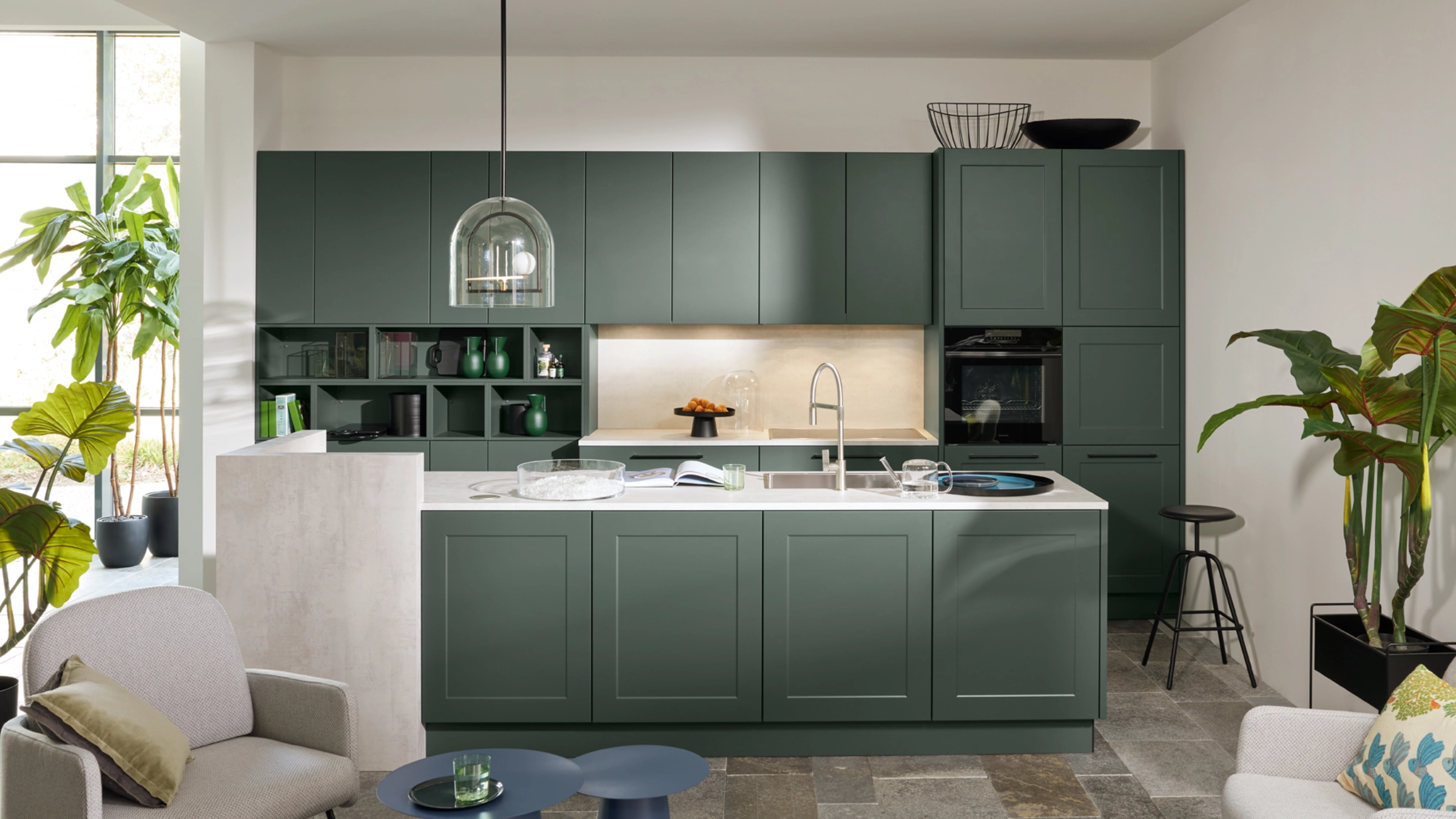 Cuisine moderne avec armoires vertes et îlot dans un espace ouvert. Nolte Kitchen.