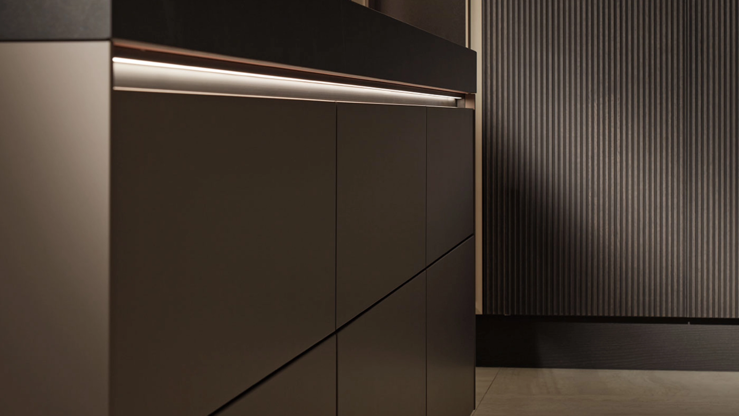 Cuisine moderne avec armoires sombres élégantes et éclairage de Nolte Kitchen.
