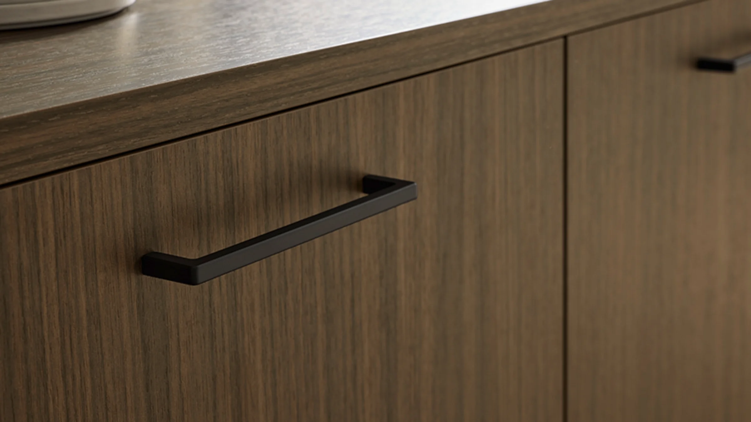 Fronty do kuchni, pomieszczenia gospodarczego, salonu lub łazienki. Nolte Küchen oferuje więcej niż kuchnie. Tutaj widoczny program frontów MANHATTAN UNI z dekorem Dąb Nero z uchwytami.