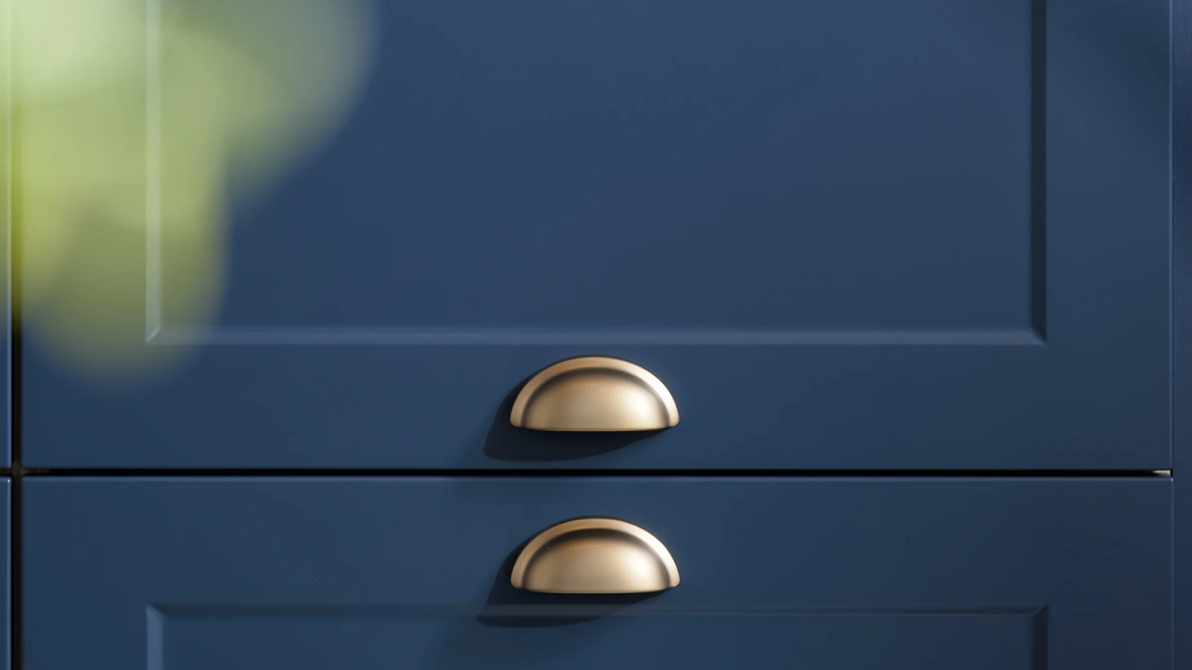 Elegante credenza blu con maniglie dorate. Nolte Küchen.