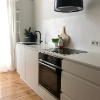 Cuisine moderne avec armoires blanches et sol en bois de Nolte Kitchen.