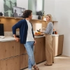 Un homme et une femme discutent dans une cuisine moderne avec des placards en bois de Nolte Kitchen.