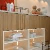Een moderne keuken met houten kasten en verlichte planken van Nolte Kitchen.