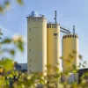 Three yellow silo towers of a factory with "nolte küchen" written on them under a blue sky.