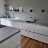 Eine moderne Küche mit weißen Schränken und Holzfußboden, präsentiert von Nolte Küchen.