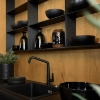 Een moderne keuken met een zwart werkblad en houten planken, ontworpen door Nolte Kitchen.