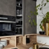 Cuisine moderne avec armoires grises et détails en bois, décorée de plantes. Nolte Kitchen.