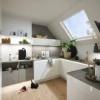 A modern kitchen with white cabinets and skylight; Nolte Kitchen.