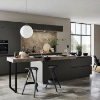Une cuisine moderne avec îlot, tabourets et carrelage en pierre; design Nolte Kitchen.