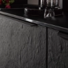 Une cuisine moderne avec façades sombres texturées et détails élégants de Nolte Kitchen.