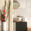 Une salle de bain moderne avec des carreaux blancs et des éléments décoratifs. Nolte Kitchen.