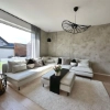 Un salon moderne avec un grand canapé d'angle et un tapis clair, habilement conçu par Nolte Living.