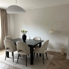 Une salle à manger élégante avec table sombre et chaises claires, assortie à Nolte Living.