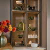 Une étagère de salon élégante avec vases en verre et vaisselle, assortie à Nolte Living.
