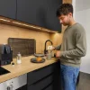 Un homme prépare du café dans une cuisine moderne de Nolte Kitchen.