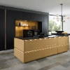 Cuisine moderne avec îlot doré et armoire noire, éclairée par une suspension. Nolte Kitchen.