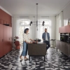 Eine moderne Küche mit roten Schränken und geometrischem Bodenmuster, Nolte Küchen.